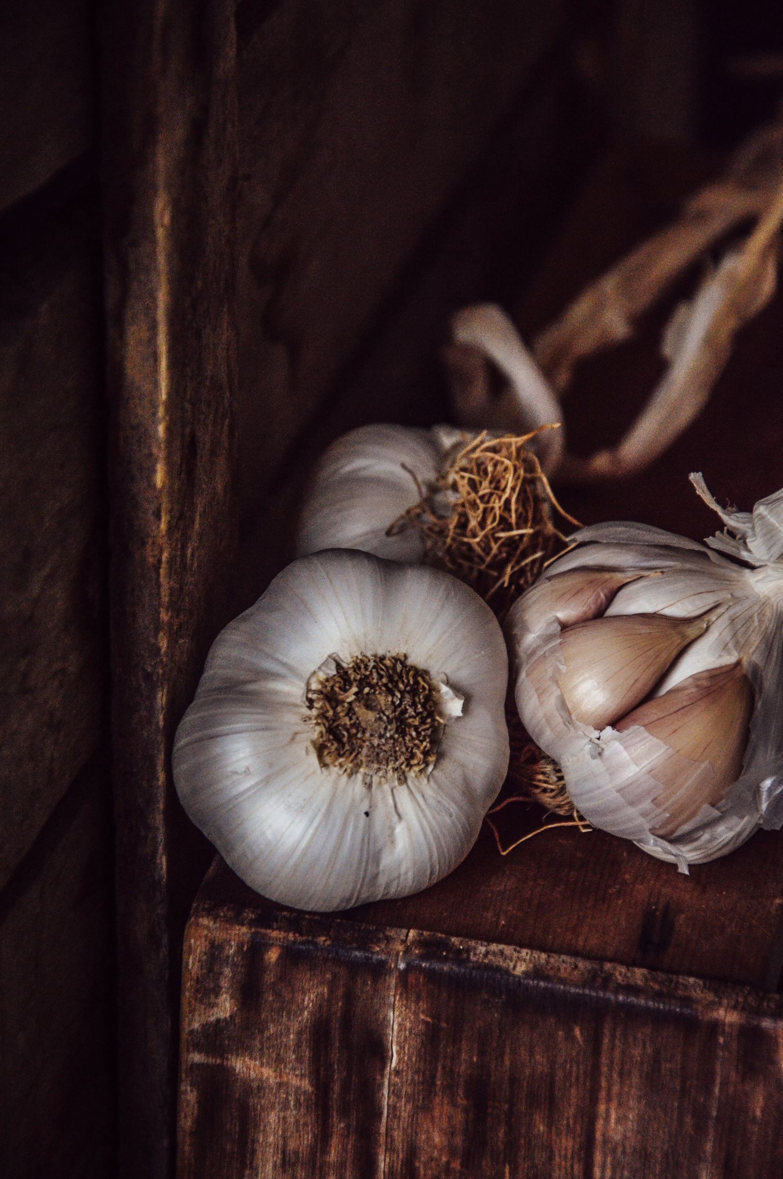Garlic bulbs and shallots on a dark wooden board